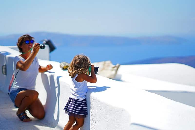 Criança tirando fotos em Santorini