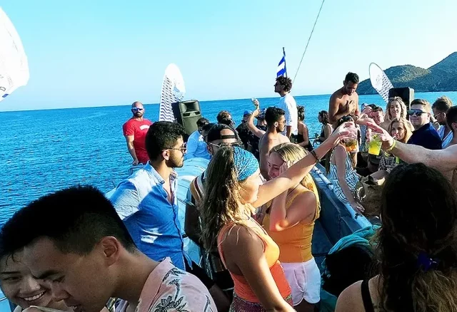 Festa no barco por Mykonos ao entardecer